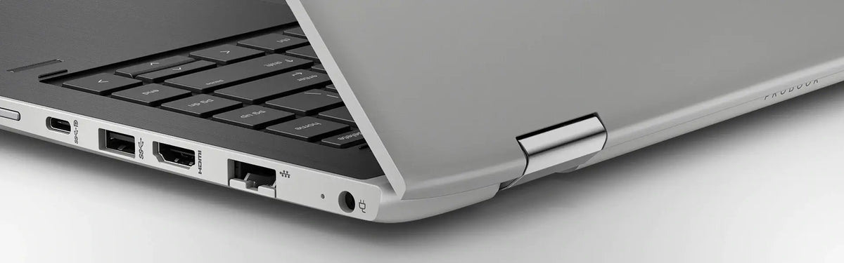 a close-up view of the side of a laptop computer, focusing on the keyboard and the laptop's ports and connections.