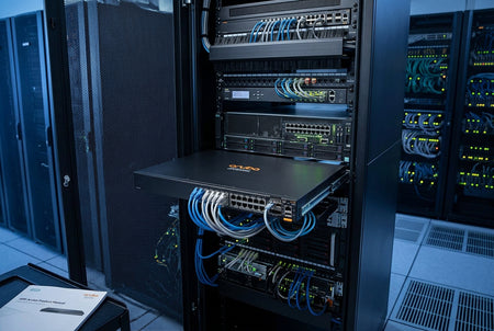 um dispositivo eletrônico preto com uma fileira de portas na frente, provavelmente um dispositivo de rede ou um computador.